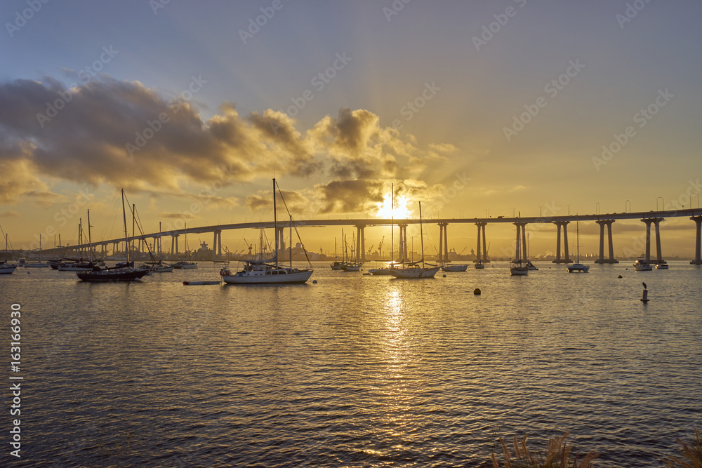 boats under and beautiful sunrise over the Coronado Bridge, San Diego California