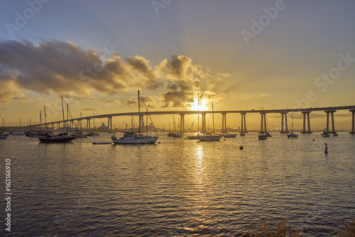 boats under and beautiful sunrise over the Coronado Bridge, San Diego California © Alicia
