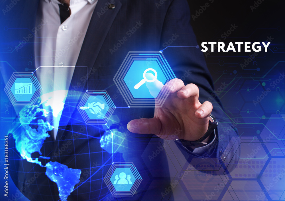 The concept of business, technology, the Internet and the network. A young entrepreneur working on a virtual screen of the future and sees the inscription: Strategy The concept of business, technology, the Internet and the network. A young entrepreneur working on a virtual screen of the future and sees the inscription: Strategy