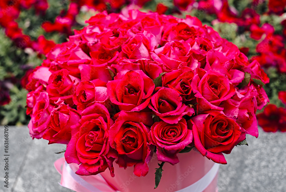 Beautiful flower bouquet of pink roses in big round pink hat box with  ribbon outdoors. Work florist. Mother's Day Stock Photo | Adobe Stock