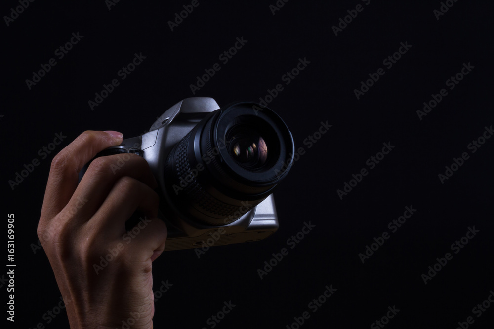 Hand holding Camera on black background Hand holding Camera on black background