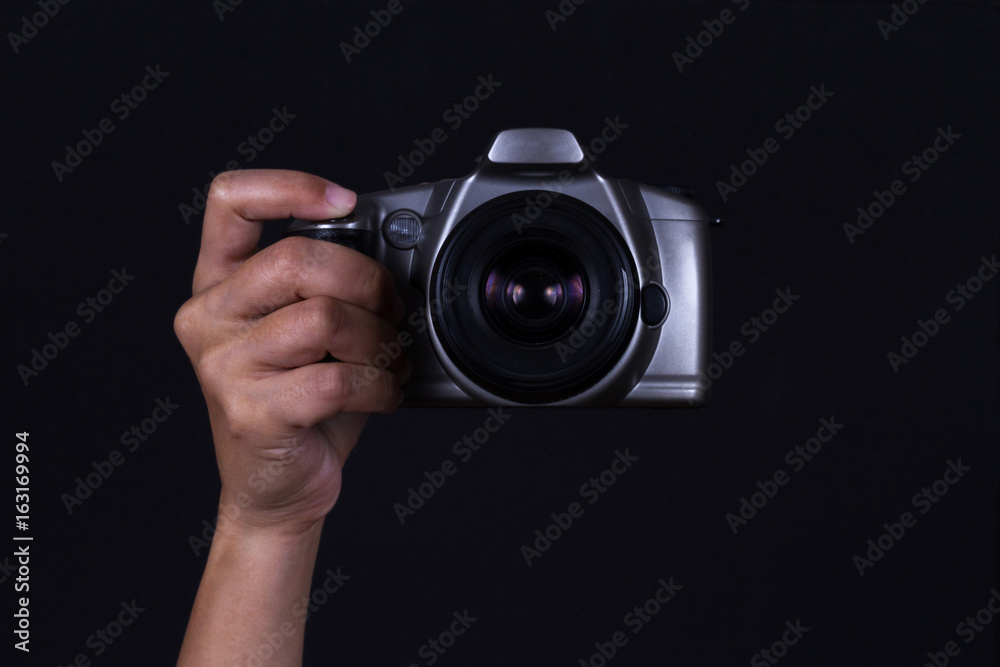 Hand holding Camera on black background