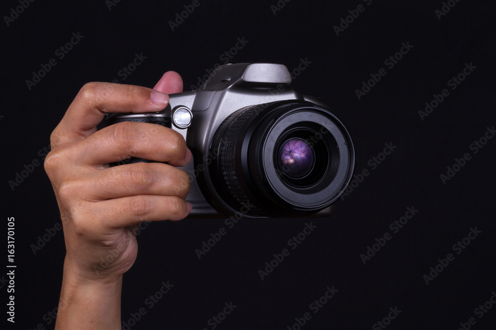 Hand holding Camera on black background