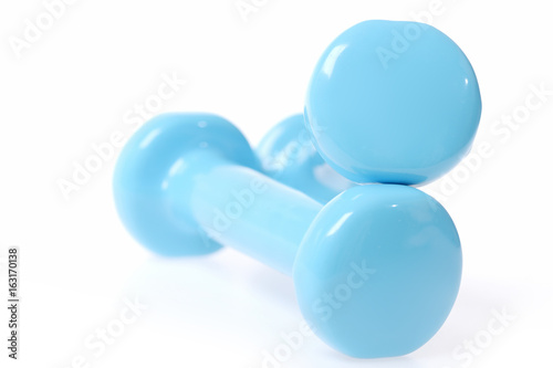 Light blue sports equipment: cyan dumbbells lying on each other