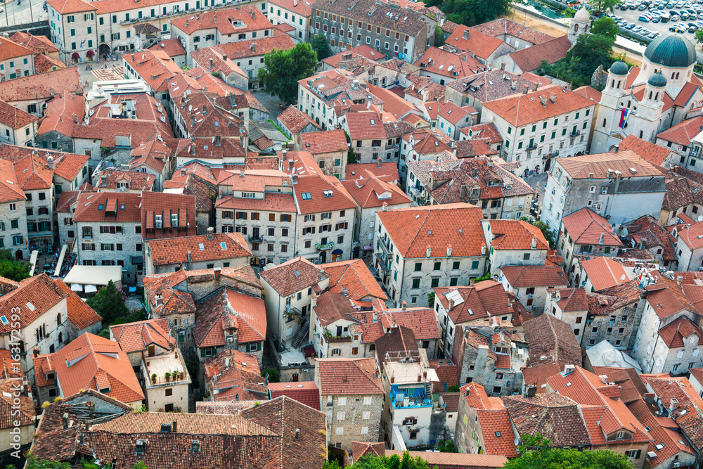 View of tiled roofs of old town ang the church from the fortress on the hill in Kotor in Montenegro