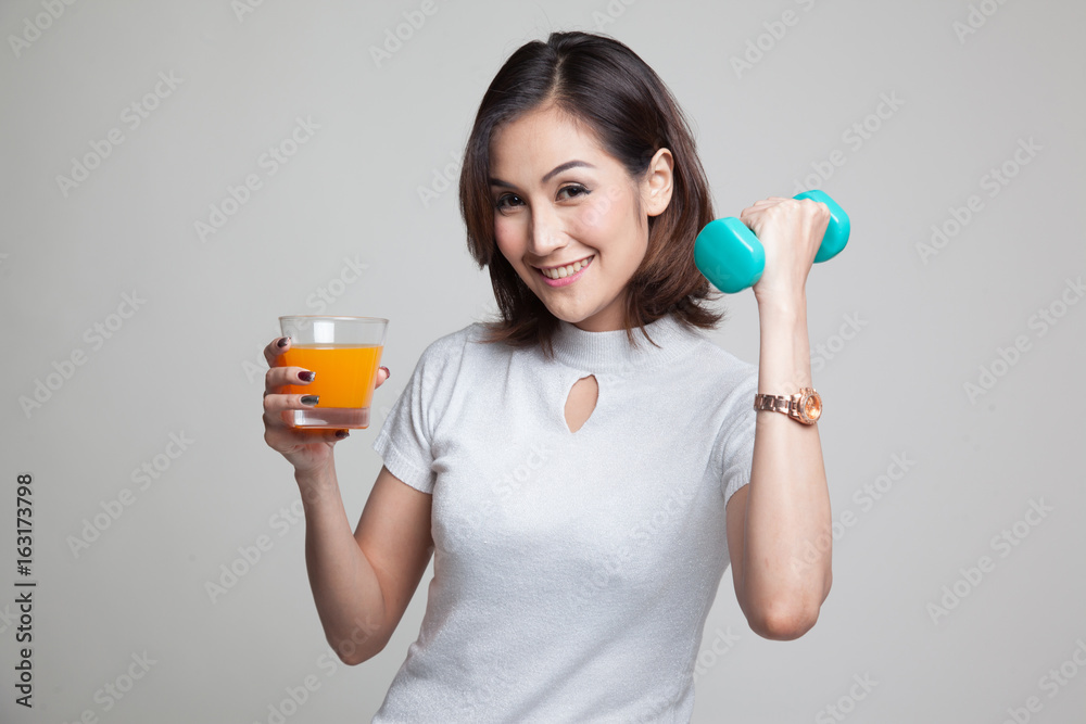 Young Asian woman with dumbbell drink orange juice. Young Asian woman with dumbbell drink orange juice.