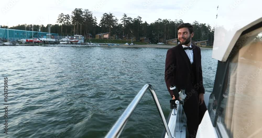 Stylish businessman on a yacht or boat against a sea. He is pleased with the success in his business and his team Partner, we're in Business Luxury traveling and working. Stylish businessman on a yacht or boat against a sea. He is pleased with the success in his business and his team Partner, we're in Business Luxury traveling and working.