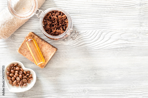 Homemade skin care. Coffee soap, coffee scrub, coffee grains, oil on wooden background top view copyspace