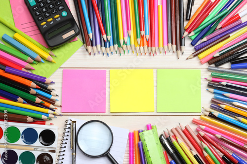 school and office supplies. school background. colored pencils, pen, pains, paper for school and student education on white wooden background. top view with copy space