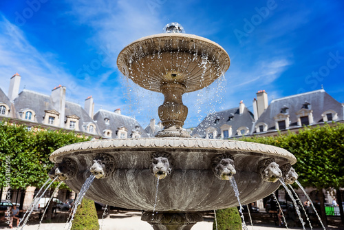 Fountain in the Place des Vosges (Place Royale) - the oldest squere in Paris located in Le Marais district. photo