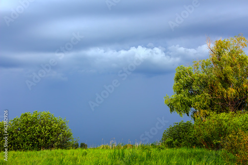 Landscape with storm clouds over a green meadow
