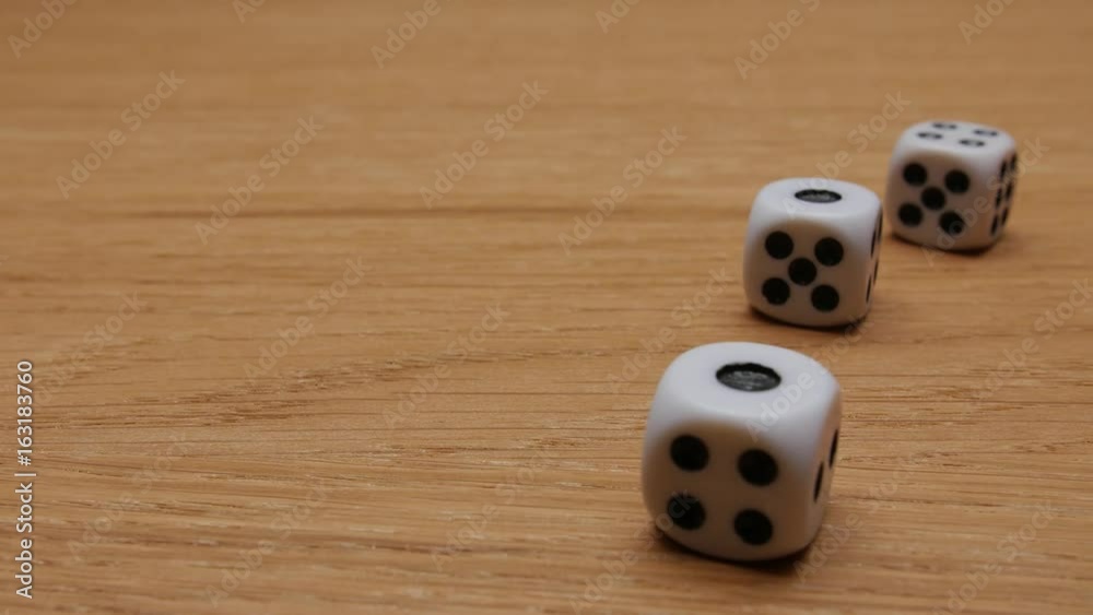 Dice rolling on the brown table. Close-up. Dice rolling on the brown table. Close-up.