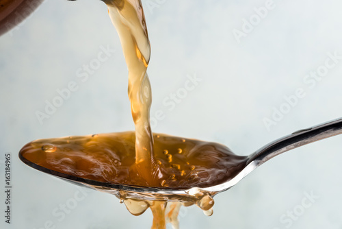 Pouring Apple Cider Vinegar on a Spoon photo