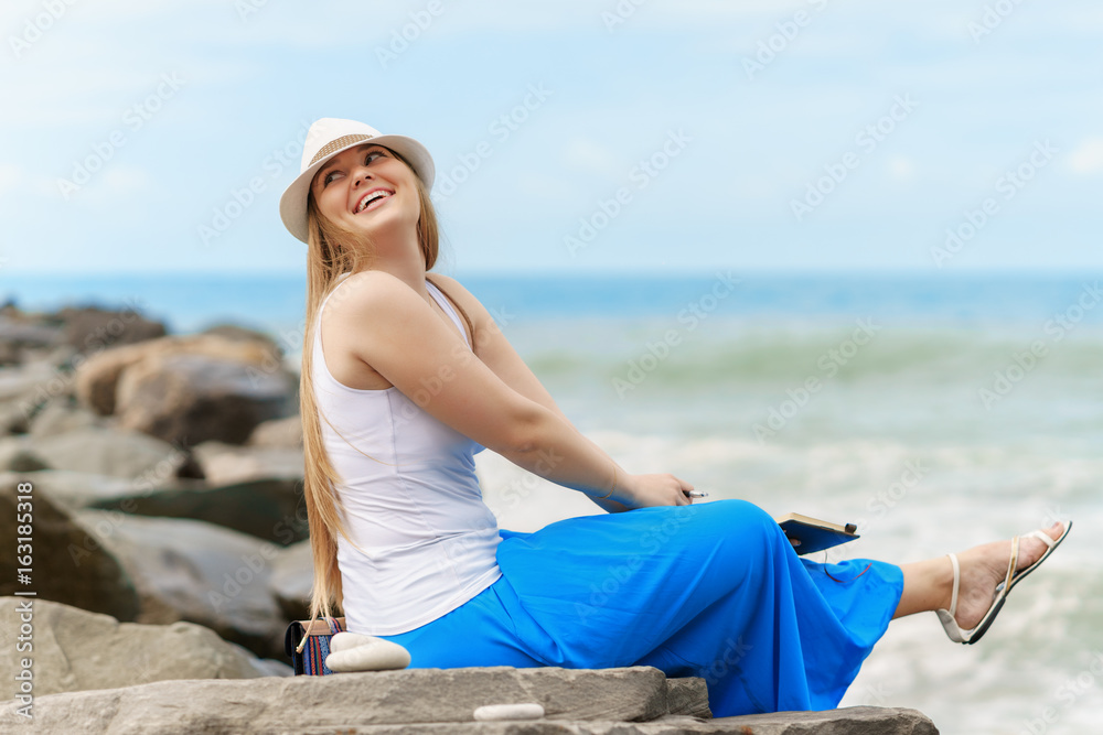 young caucasian woman sits on the shore