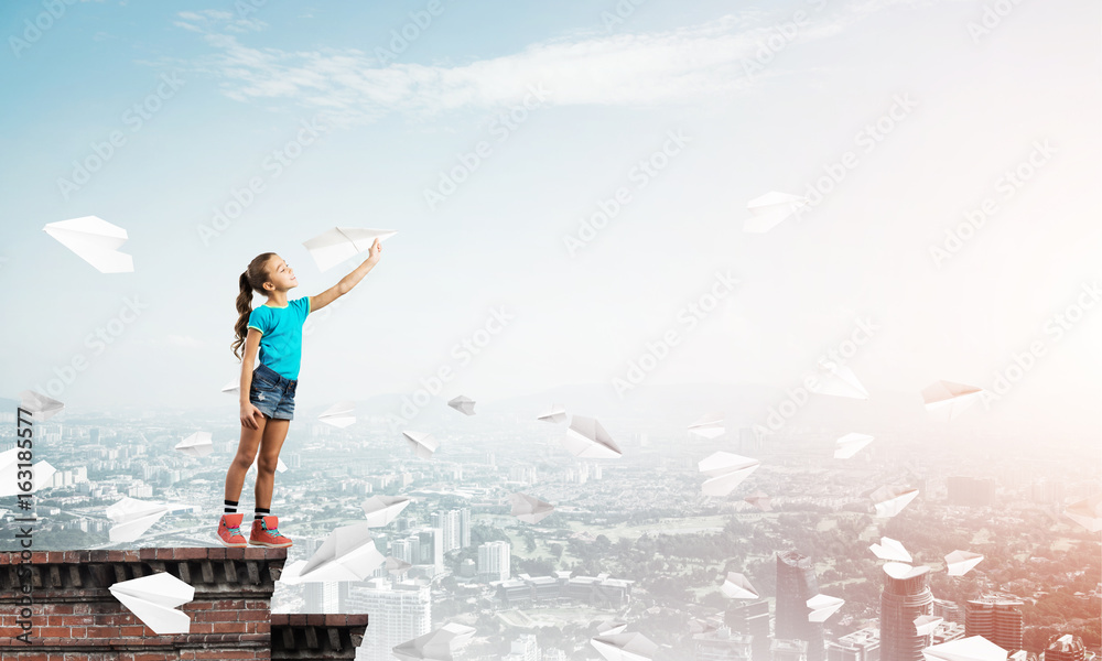 Concept of careless happy childhood with girl dreaming to become pilot Concept of careless happy childhood with girl dreaming to become pilot