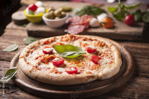 rustic italian pizza with mozzarella, cheese and basil leaves
