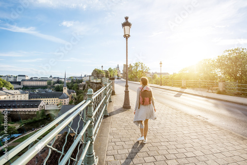 Woman walking on the bridge with great view on the old town of Luxembourg city