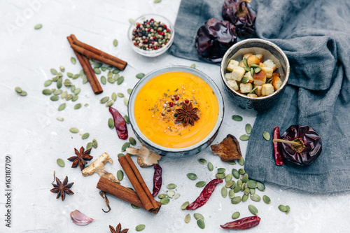 Bowl with carrot soup and spices. Flat lay styling