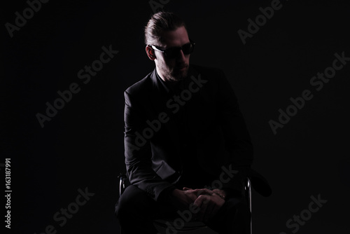 Mann in schwarzem Anzug vor schwarzem Hintergrund © Wellnhofer Designs
