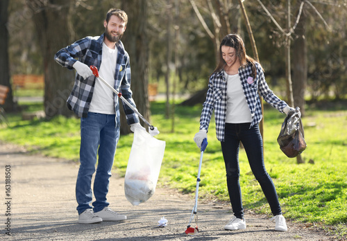 Young volunteers picking up litter in park