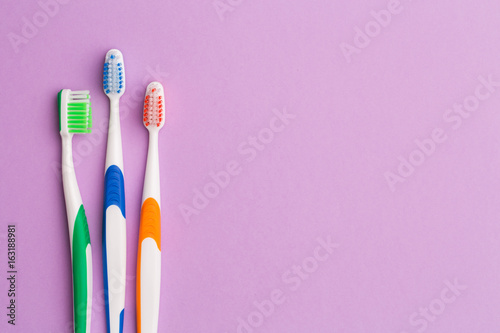 Photo of three multi-colored toothbrushes