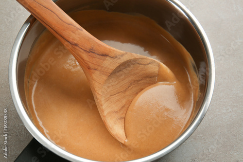 Delicious turkey gravy in saucepan on table photo