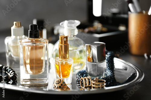 Tray with perfume bottles and accessories on table