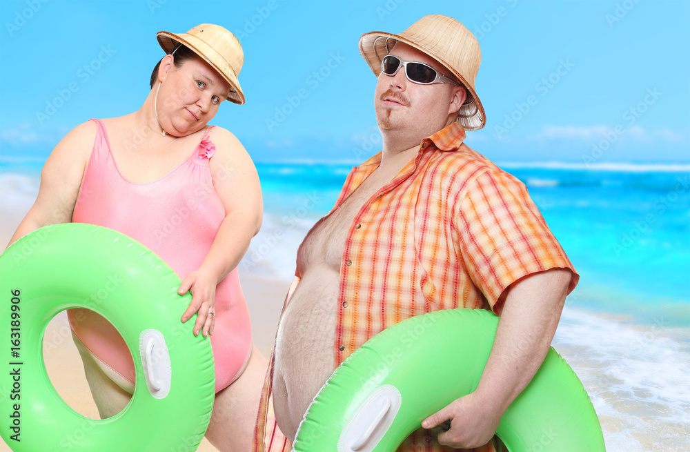 Obese couple in swimsuit with green lifebuoy. Holidays on the   people sending greeting from tropical paradise. Stock Photo | Adobe Stock