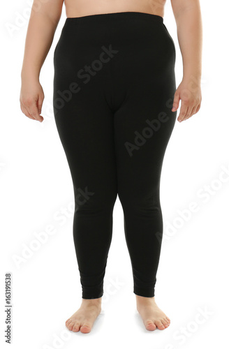 Overweight woman in black leggings on white background. Diet concept