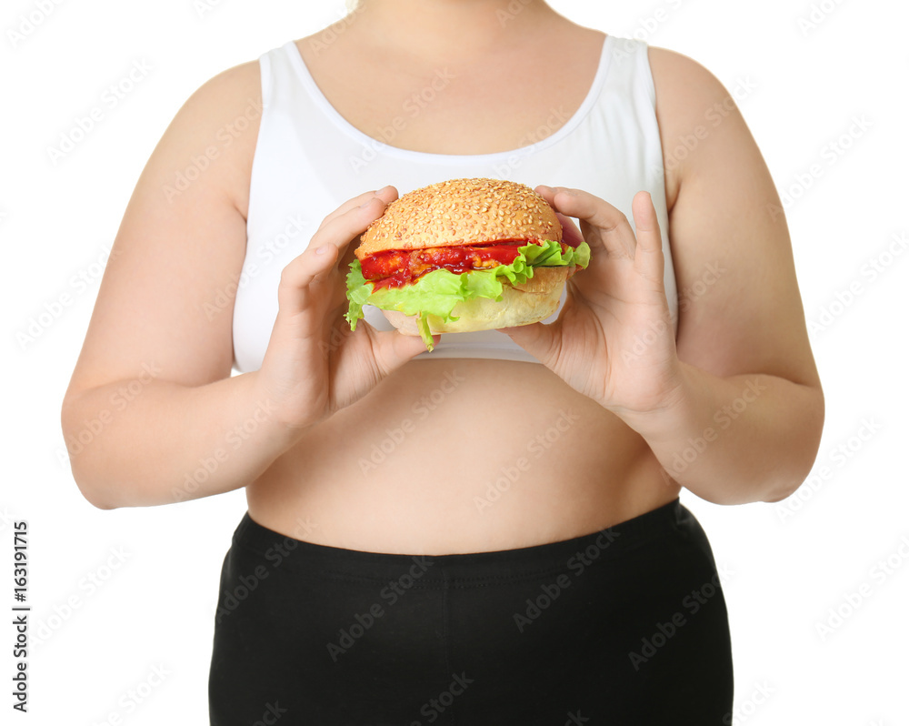 Overweight young woman with burger on white background. Diet concept Overweight young woman with burger on white background. Diet concept