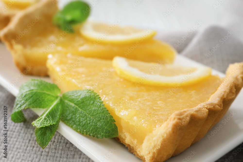 Pieces of tart decorated with mint and lemon slices on plate Pieces of tart decorated with mint and lemon slices on plate