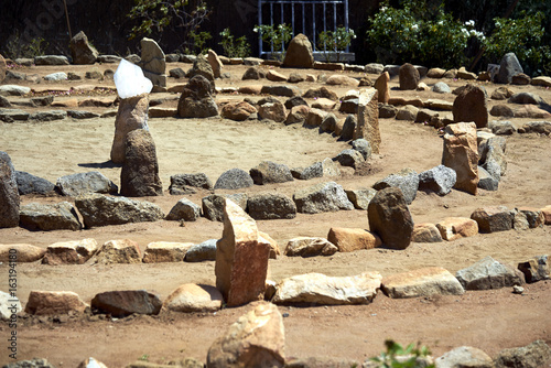 Large stone and sand labyrinth bathed in mid-day sunlight; crystal center stone to gather your thoughts