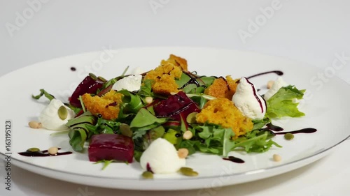 Salad with herring, beetroot, paprika, red onion, mustard and balsamic vinegar. Salad of lettuce, beetroot and salmon fillets with a delicate cream sauce. Salad with greens, fish and beetroot photo