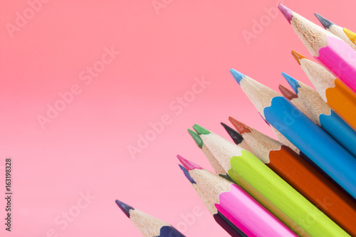 colorful pencil stack on the orange background photo