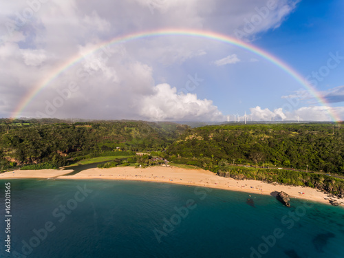 Aerial view of Waimea bay with a full rainbow on the north shore of Oahu Hawaii