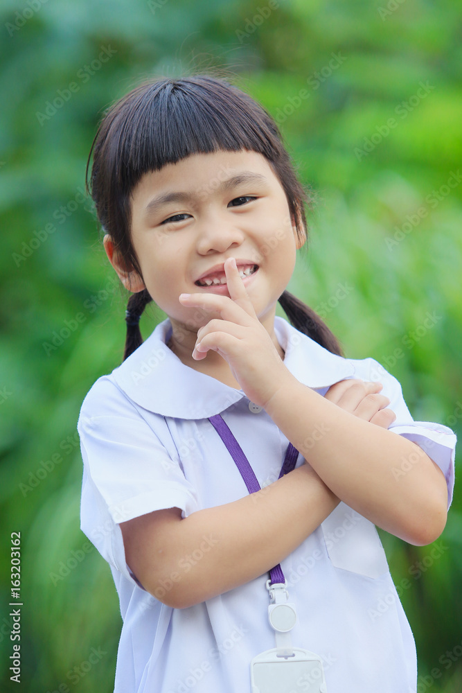 toothy smiling happiness face of asian children against green blur background toothy smiling happiness face of asian children against green blur background