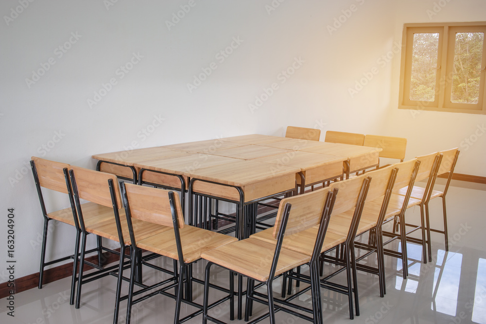 Fototapeta premium light empty classroom for lessons and training group in high school, wood table and chairs.