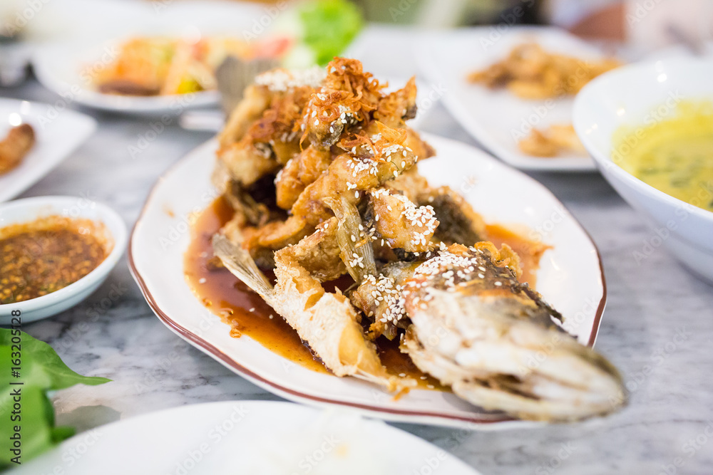 Deep Fried Sea Bass with Sauce on white dish,Thai food. Deep Fried Sea Bass with Sauce on white dish,Thai food.