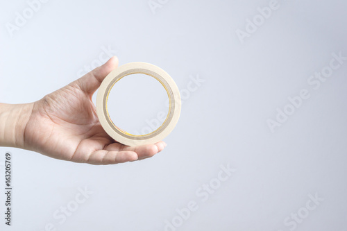 Hand holding paper tape roll