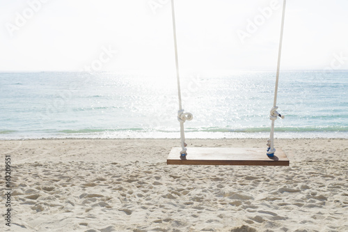 Swing at the beach with sunlighted water in front of the ocean, nusa lembogan, Bali, Indonesia photo