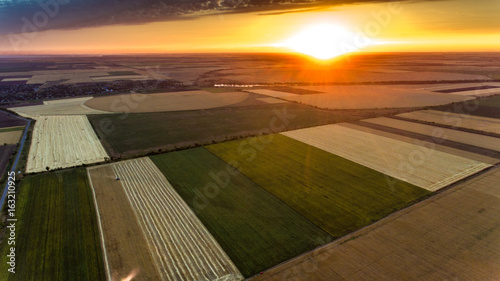 Aerial shot of an agricultural multicolored field at sunset in Eastern Europe