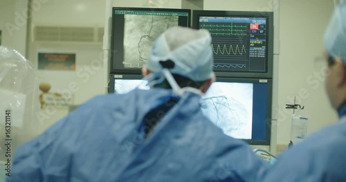 Surgeons watching monitors with x-ray images during a Cardiac catheterization procedure