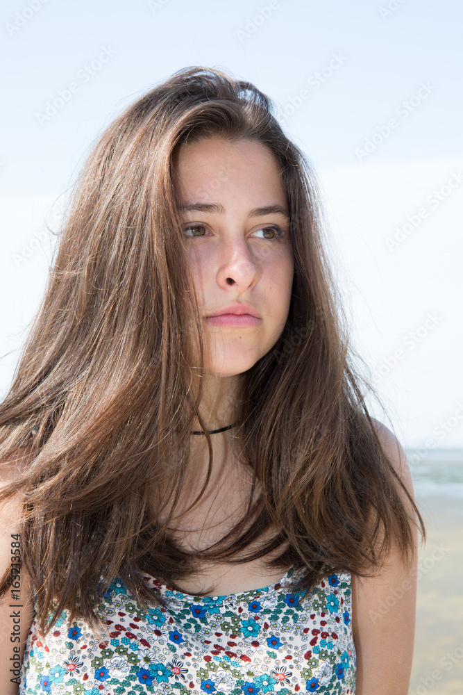 beautiful brunette girl standing in a summer beach