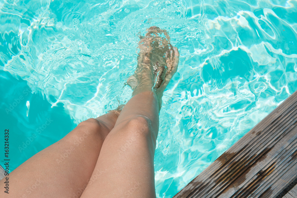 Young woman's legs in the swimming pool