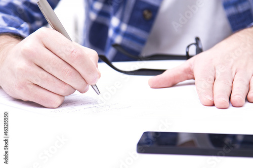 Young man signing paper work in the office © tetxu