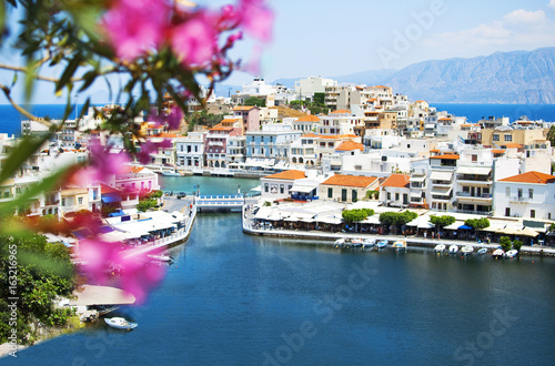 View of Lake Voulismeni in Agios Nikolaos, Crete, Greece. A beautiful coastal city with colorful buildings. © olgaarkhipenko