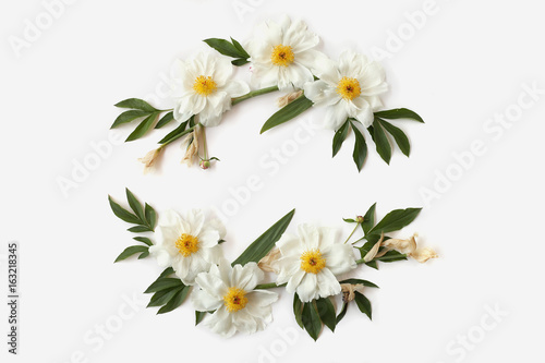 Floral wreath with white peonies, buds and needle-shaped leaves of iris isolated on white background. Flat lay, top view. Mother`s day concept.