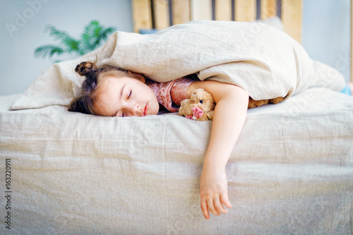 Adorable little child girl sleeping in the bed