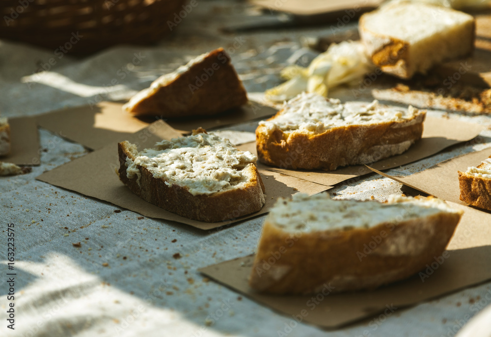 Pieces of fresh bread with some spread on it and craft paper under, warm sunlight Pieces of fresh bread with some spread on it and craft paper under, warm sunlight