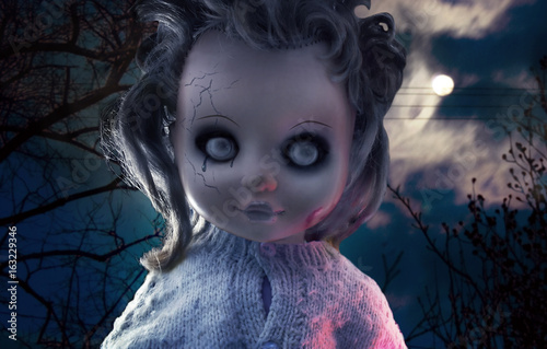 Scary doll photo. Scary ghost plastic doll with black tears on mystic night nature background photo. photo